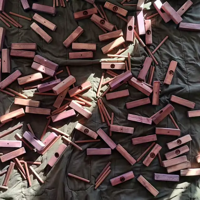 Dozens of freshly stained wooden parts spread out on a canvas sheet to dry.