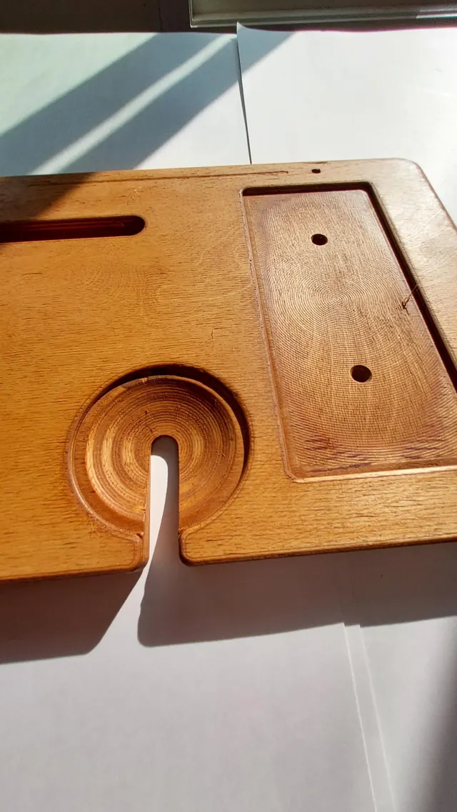 The end of the board, showing the bowled wine-glass notch with its slot cut through to the edge, beside the raised backstand of the tablet groove.